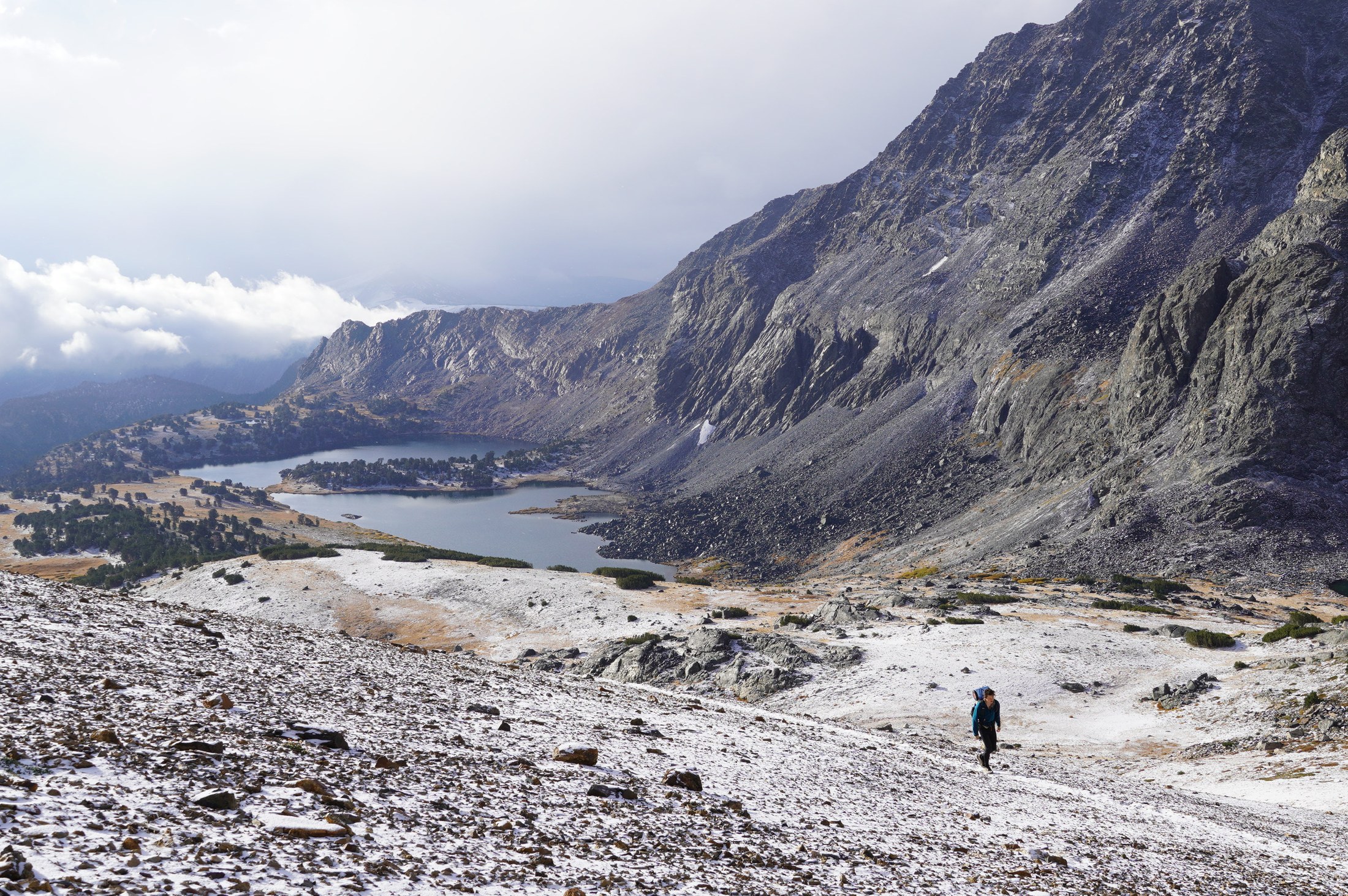 Climbing toward the pass above snow-dusted lakes